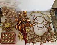 Photo of all items including brass decorative horns, assorted gold and brown tree ornaments, jingle bells, and illuminated snowflake tree topper.