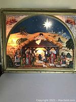 Full front image of the illuminated 3D plastic vintage Christmas nativity sign showing the stable with nativity figures and starry sky background