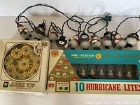 Lot showing vintage snowman string lights and 10 hurricane light Christmas tree topper in original box.