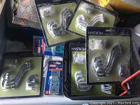 Multiple packages of Nystrom ReadyHook multi-pack hooks in chrome and white finishes, along with lock brackets in original packaging.