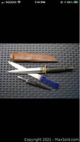 Photo showing three cutting tools: a large hand forged cutting tool with black handle and brown leather sheath, a silver plated letter opener with Dominion Combing Mills inscription, and a small sculptor's cutting tool with blue label.
