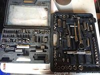 Two miscellaneous tool sets including socket wrenches, sockets, and accessories arranged inside black plastic cases.