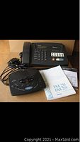 Photo showing Brother push button phone with fax, GE answering machine, and manuals for Brother Fax 255 and 275.