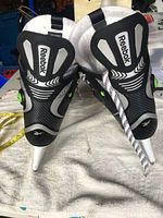 Front view of the Reebok XT Comp skates emphasizing black and white design with Reebok logos on tongues and white laces.