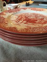Stacked view of 6 Royal Stafford Santa's Sleigh red colored dinner plates, showing plate edges and thickness.