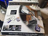 Front of Shark Portable Steam Pocket box with product image, usage scenario, and text indicating features.