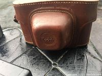 Brown leather carrying case embossed with Kodak on the front flap.
