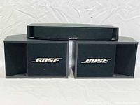 Front view of Bose 201-II left and right speakers with Bose VCS-10 center speaker placed on top. Speakers have black fabric grilles with Bose logos.