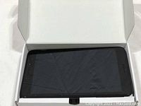 Top-down view of the ZTE tablet face with the screen visible inside the open box, showing the black bezel and touchscreen display.