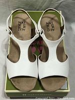 Top view showing white leather upper, beige cushioned footbed with Naturalizer branding.