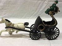 Side view of the assembled antique cast iron horse and carriage with driver showing the separate pieces fitted together producing a 14-inch long decorative set