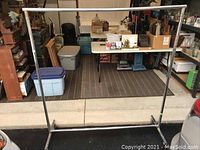 Full view of the large metal mobile coat rack showing dimensions and structure