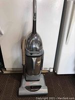 Full upright view of Hoover Windtunnel vacuum showing overall condition and hose attachment.