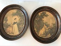 Two oval plaques with Victorian scenes side by side showing full fronts.