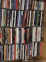 Photo showing a large assortment of CDs in jewel cases with visible spines revealing various artists and album titles.