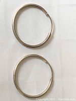 Top view showing the pair of silver hoop earrings, closed and lying flat.