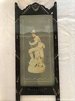 Photo of full antique wooden frame with glass-covered picture of outdoorsman and dog, showing hand-carved and painted decorative elements on frame edges.