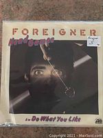 Close-up of Foreigner 45 RPM single titled 'Head Games / Do What You Like' in original paper sleeve with some wear noted.