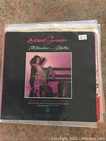 Stack of over twenty 45 RPM vinyl records with sleeves showing Donna Summer record on top