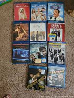 Photo showing ten Blu-ray movie cases arranged upright on a carpeted floor.