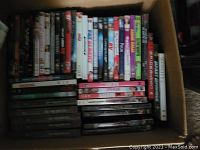 Box containing multiple DVDs arranged with spines visible showing various titles.