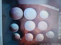 Photo showing 12 assorted white dishes arranged on a surface including large plates, smaller plates, and bowls.
