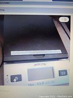 Front angle view showing black weighing platform and digital screen indicating scale specifications and power button.