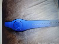 Blue Disney MagicBand wristband with Mickey Mouse icon and adjustable holes