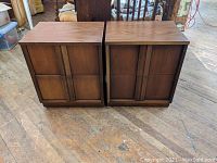 Pair of walnut nightstands side by side showing front and top views, revealing wood grain and design.