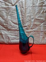 Full front view of the mid-century teal Viking Glass pitched with slender, long spout and round base.