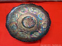 Top view showing full circular design with dragons and lotus flowers in raised relief and iridescent blue carnival glass finish.