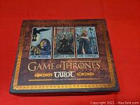 Closed original box featuring three tarot card images: The Hermit, Queen of Swords, The Empress, with Game of Thrones Tarot branding.