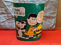 Front view of the trash can showing Snoopy, Lucy, and Charlie Brown with dialogue bubble 'READY... ON THE SET!!'
