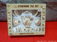 Original boxed 12-piece stoneware tea set for four with Holly Hobby style character illustrations in brown on cream background.