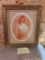Framed oil painting portrait showing a woman's back with hair in an updo, signed by Raymen, dated 1983, with an ornate frame and visible foxing.