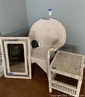 White wicker chair, rectangular mirror, and small table grouped together showing size and condition