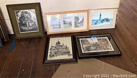 Five assorted framed prints on floor showing various buildings and landscapes, some in black and white and some in color