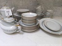 Full set of Empress Japan porcelain plates, serving platters stacked, cups stacked, and bowls with teapot, sugar bowl, and creamer assembled.