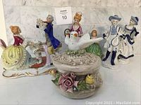 Group photo showing all six porcelain figurines including dancing couple, music couple, child, and candy dish with bird and floral decorations.