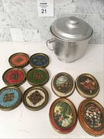 Full lot displayed on white surface: 12 round Florentine coasters, 4 oval framed pictures, and aluminum ice bucket with lid and handle