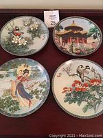 Four Bradford Exchange collector plates displayed on a flat surface showing detailed artwork of birds, flowers, pavilion, and traditional woman.