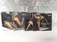 Front view of 5 different tights packages showing various Wolford models including fishnets and velvet styles.