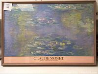 Framed Claude Monet water lilies print image showing impressionist water lilies on a blue-green water background with dark wood frame and chips on frame.