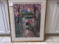 Photo of Kids in Garden framed painting depicting a garden pathway with flowering trees, showing some frame wear/chips.