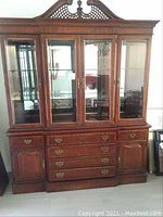 Front view of the solid mahogany china cabinet showing four glass display doors in the upper section and multiple drawers and lower cabinets in the base.