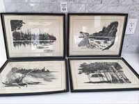 Four framed black ink sketches by Roy Hewetson displayed together on marble floor, showing natural landscapes in black and white with reflections and rocky textures.