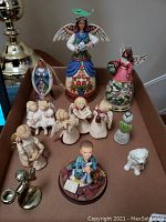 Photo showing box with various angel and child figurines including large Jim Shore angels and smaller collectible angels