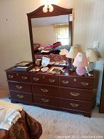 Front view of dresser and attached mirror with items on top
