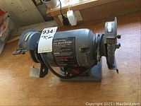 Side view of Craftsman 5-in bench grinder showing power cord and mounted on table
