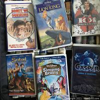Top-down photo showing a selection of Walt Disney VHS movies including Honey, We Shrunk Ourselves, The Lion King, and 101 Dalmatians among others.